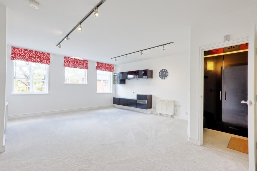 Lot: 6 - ATTRACTIVE TWO-BEDROOM APARTMENT IN CONVERTED FORMER HOSPITAL BUILDING - Carpeted living area with 3 windows and media cabinet